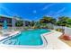 Community pool with patio table and chairs, mature landscaping and fence; beautiful blue sky on a sunny day at 6108 7Th W Ave # 6108, Bradenton, FL 34209