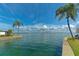 Breathtaking waterfront view with clear blue skies, palm trees, and serene turquoise water at 669 Spanish N Dr # 21, Longboat Key, FL 34228