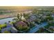 An aerial view showcases a single-story home with a tile roof near a golf course and a serene lake at 6914 Dominion Ln, Lakewood Ranch, FL 34202