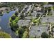 Aerial view of community tennis courts and pond, surrounded by lush greenery and parking at 6914 Dominion Ln, Lakewood Ranch, FL 34202