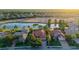 Aerial view of a beautiful home with a tile roof, situated on a golf course with a scenic lake view at 6914 Dominion Ln, Lakewood Ranch, FL 34202