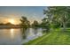 Tranquil backyard view features mature trees, sunset, and a pond at 6914 Dominion Ln, Lakewood Ranch, FL 34202
