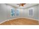 This bedroom features hardwood floors, three windows for ample natural light, and a ceiling fan at 6914 Dominion Ln, Lakewood Ranch, FL 34202