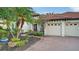 A well-maintained home showcases its brick paver driveway, two-car garage, and lush tropical landscaping at 6914 Dominion Ln, Lakewood Ranch, FL 34202