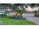 Charming single-story home featuring a paver driveway, 2-car garage, tile roof, and meticulously landscaped front yard at 6914 Dominion Ln, Lakewood Ranch, FL 34202