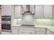 Close up of the kitchen featuring a stainless oven, hood, and decorative backsplash at 6914 Dominion Ln, Lakewood Ranch, FL 34202