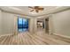 Bright living room boasts light hardwood floors, a tray ceiling with fan, and glass doors with pool views at 6914 Dominion Ln, Lakewood Ranch, FL 34202