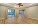 Spacious room with hardwood floors, neutral paint, tray ceilings, and glass sliding doors with outdoor pool views at 6914 Dominion Ln, Lakewood Ranch, FL 34202