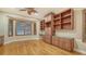 Spacious office with hardwood floors, built in wood shelving, cabinets, drawers, and natural light from a large window at 6914 Dominion Ln, Lakewood Ranch, FL 34202