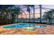 Stunning screened pool and spa overlooking a serene lake at twilight at 6914 Dominion Ln, Lakewood Ranch, FL 34202