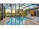 Inviting screened pool and spa with outdoor kitchen and a scenic lake view at 6914 Dominion Ln, Lakewood Ranch, FL 34202