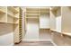 Walk-in closet with laminate wood flooring and custom shelving and clothing rods at 6914 Dominion Ln, Lakewood Ranch, FL 34202
