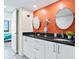 Bathroom with granite counters, double sinks, and an orange accent wall at 707 S Gulfstream Ave # 301, Sarasota, FL 34236