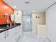 Bathroom featuring marble floors, shower, granite countertop, and an orange accent wall with starfish decor at 707 S Gulfstream Ave # 301, Sarasota, FL 34236