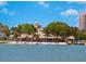 Charming beach restaurant with palm trees, thatched roofs, and waterfront seating at 707 S Gulfstream Ave # 301, Sarasota, FL 34236