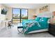 Bright bedroom with a water view, desk, and a cozy bed featuring a white and teal floral pattern at 707 S Gulfstream Ave # 301, Sarasota, FL 34236