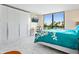 Bedroom with a large closet, desk, TV, water view, and a bed with a vibrant teal floral comforter at 707 S Gulfstream Ave # 301, Sarasota, FL 34236