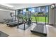 Modern gym area with treadmills and elliptical machines overlooking a green space at 707 S Gulfstream Ave # 301, Sarasota, FL 34236