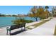 Picturesque waterfront view along a sidewalk with benches, trees, and a tranquil bay at 707 S Gulfstream Ave # 301, Sarasota, FL 34236
