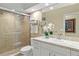 Well-lit bathroom with a modern vanity, enclosed shower, and decorative mirror at 7331 Villa D Este Dr, Sarasota, FL 34238
