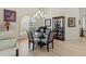 A dining area featuring a glass-topped table, four gray chairs, a decorative cabinet, and a modern chandelier at 7331 Villa D Este Dr, Sarasota, FL 34238