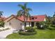 Charming home featuring a well-manicured lawn and lush tropical landscaping at 7331 Villa D Este Dr, Sarasota, FL 34238