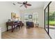 Bright home office with wood desk, fan, and view to the screened patio at 7331 Villa D Este Dr, Sarasota, FL 34238