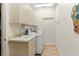Functional laundry room with washer, dryer, utility sink, and ample cabinet space at 7331 Villa D Este Dr, Sarasota, FL 34238