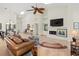 Open-concept living room with high ceilings, ceiling fan, fireplace, and plenty of natural light at 7331 Villa D Este Dr, Sarasota, FL 34238