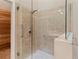 Tiled shower featuring a glass door, grab bars, and overhead shower fixture at 7331 Villa D Este Dr, Sarasota, FL 34238