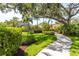 A landscaped walkway leads through lush greenery with mature trees and manicured lawns at 7331 Villa D Este Dr, Sarasota, FL 34238