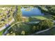 Scenic aerial view showcasing the golf course and community pond with mature trees at 7532 Marsh Orchid Cir # 8-201, Bradenton, FL 34203