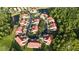 Stunning aerial view of condos in a circle, surrounded by mature trees and a serene pond at 7532 Marsh Orchid Cir # 8-201, Bradenton, FL 34203
