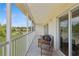 Private balcony with seating area and scenic view of lush greenery and pond at 7532 Marsh Orchid Cir # 8-201, Bradenton, FL 34203