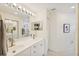 Clean bathroom with double sinks, mirrored closet doors and bright lighting at 7532 Marsh Orchid Cir # 8-201, Bradenton, FL 34203