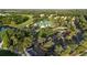 Aerial view of the clubhouse with green roof, parking, and golf carts in a lush, wooded setting at 7532 Marsh Orchid Cir # 8-201, Bradenton, FL 34203
