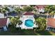 Aerial view of a stunning community pool with lounge chairs surrounded by mature trees and landscaping at 7532 Marsh Orchid Cir # 8-201, Bradenton, FL 34203