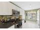 Well-lit kitchen featuring white cabinets, black countertops, and stainless steel appliances at 7532 Marsh Orchid Cir # 8-201, Bradenton, FL 34203