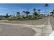 Picturesque community landscape with lush green spaces, mature palm trees, and clear blue skies at 754 Spanish S Dr # 754, Longboat Key, FL 34228