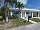 Charming single-story home with a white tile roof, blue shutters, and tropical landscaping at 754 Spanish S Dr # 754, Longboat Key, FL 34228