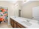 Bathroom with a long double sink vanity, large mirror, and a floral shower curtain at 8272 Summer Night Rd, Sarasota, FL 34241