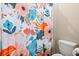Close up of the floral patterned shower curtain, toilet and paper towel holder at 8272 Summer Night Rd, Sarasota, FL 34241