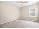 Well-lit bedroom featuring a ceiling fan, neutral carpet, and a window for natural light at 8272 Summer Night Rd, Sarasota, FL 34241