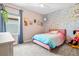 Bright bedroom featuring light pink walls, playful wallpaper accent, and comfortable furnishings at 8272 Summer Night Rd, Sarasota, FL 34241