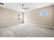 Spacious carpeted bedroom featuring neutral walls, a ceiling fan, and bright natural light at 8272 Summer Night Rd, Sarasota, FL 34241