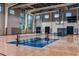 Indoor gym featuring basketball hoops, a tennis net, and ample natural light at 8272 Summer Night Rd, Sarasota, FL 34241
