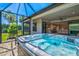 Covered patio featuring a hot tub with water and seating and view of the manicured backyard at 8272 Summer Night Rd, Sarasota, FL 34241