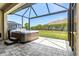 Screened in back porch featuring a hot tub with steps and brick pavers at 8272 Summer Night Rd, Sarasota, FL 34241