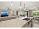 Spacious kitchen island with stainless steel sink, blends into a cozy living area with fireplace and backyard access at 8272 Summer Night Rd, Sarasota, FL 34241