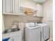 Efficient laundry room with modern washer, dryer, sink, and ample storage cabinets at 8272 Summer Night Rd, Sarasota, FL 34241
